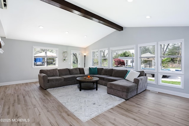 living area featuring baseboards, vaulted ceiling with beams, and light wood-style flooring