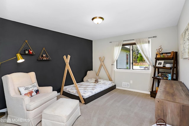 bedroom featuring baseboards, visible vents, carpet flooring, and an accent wall