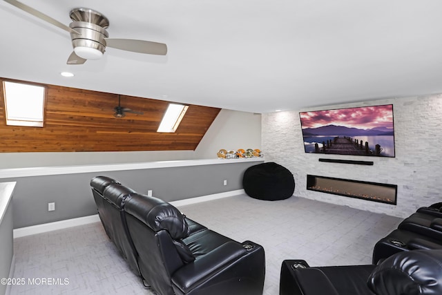 cinema with a large fireplace, a ceiling fan, and baseboards