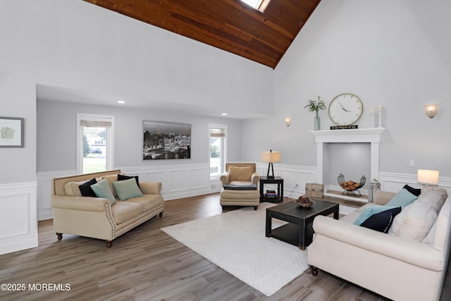 living area featuring a decorative wall, a wainscoted wall, a wealth of natural light, and wood finished floors