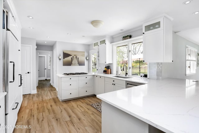 kitchen with recessed lighting, a sink, white cabinetry, light wood-type flooring, and a peninsula