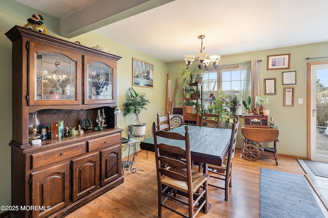 dining area with a notable chandelier and light wood finished floors