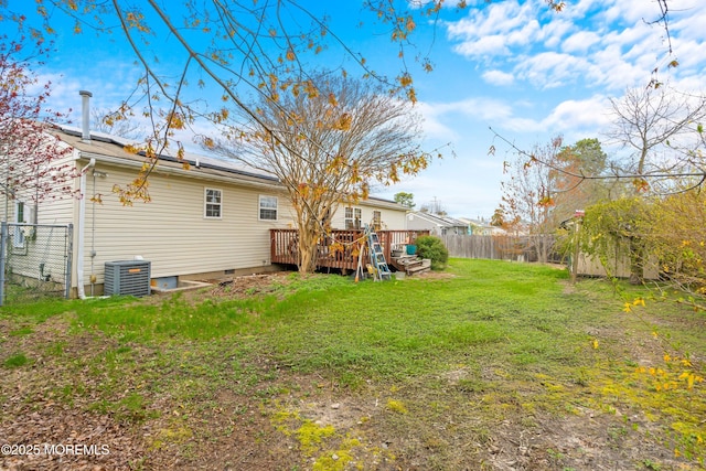 view of yard featuring fence, a deck, and central air condition unit