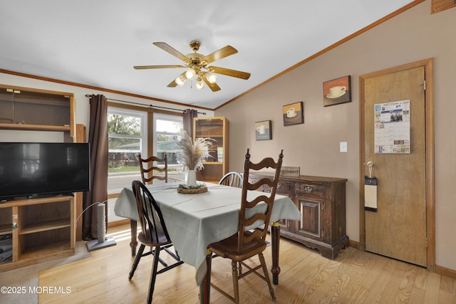 dining space featuring vaulted ceiling, ceiling fan, light wood finished floors, baseboards, and crown molding