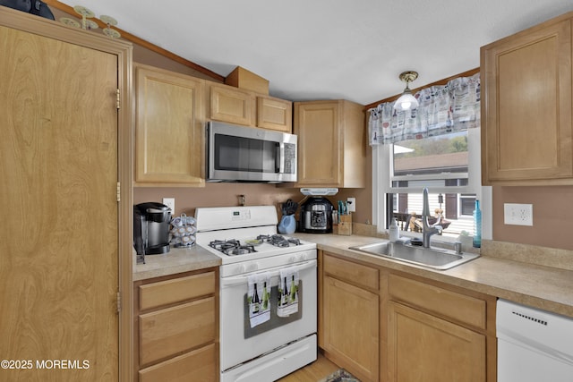 kitchen featuring light countertops, light brown cabinetry, a sink, and white appliances