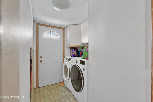 laundry room with light floors, washer and clothes dryer, and cabinet space