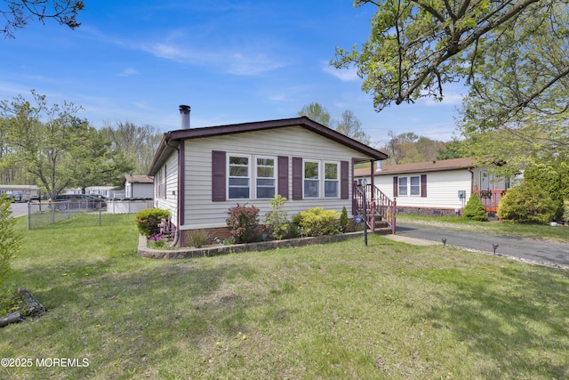 bungalow-style house with a front yard and fence