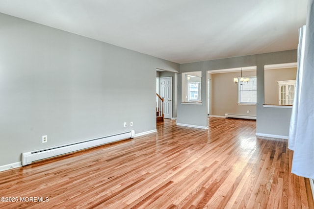 unfurnished room featuring baseboard heating, a chandelier, a baseboard heating unit, light wood-style flooring, and baseboards