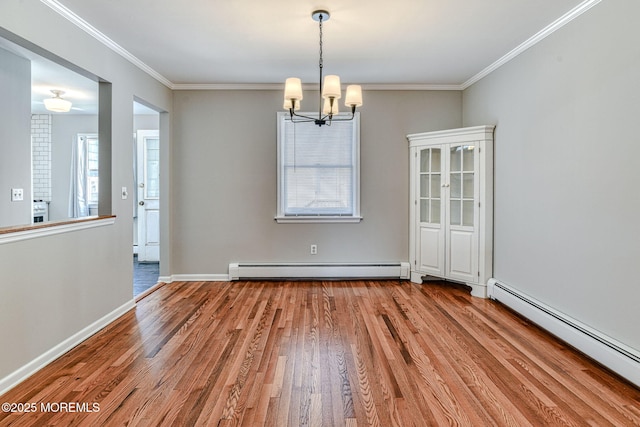 empty room featuring a baseboard heating unit, wood finished floors, a baseboard radiator, a chandelier, and crown molding