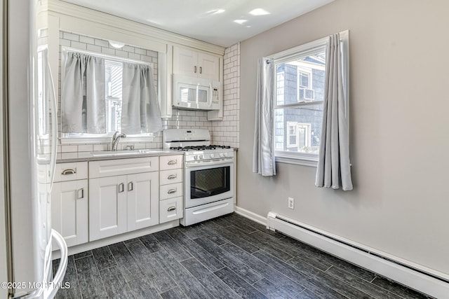 kitchen with white appliances, a baseboard heating unit, tasteful backsplash, white cabinets, and light countertops