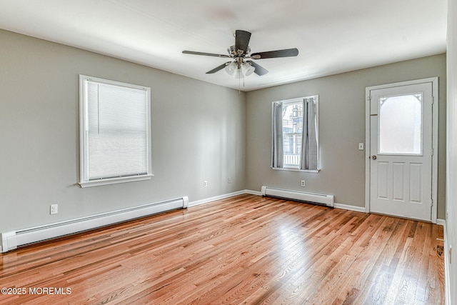 empty room with a baseboard radiator, light wood-style floors, ceiling fan, and baseboards