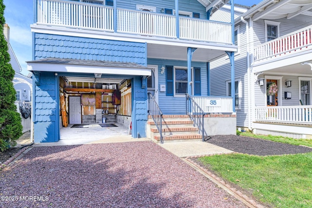 doorway to property featuring a balcony, covered porch, and a garage
