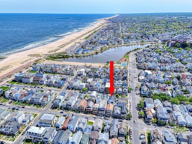aerial view of property's location featuring expansive beach and nearby suburban area