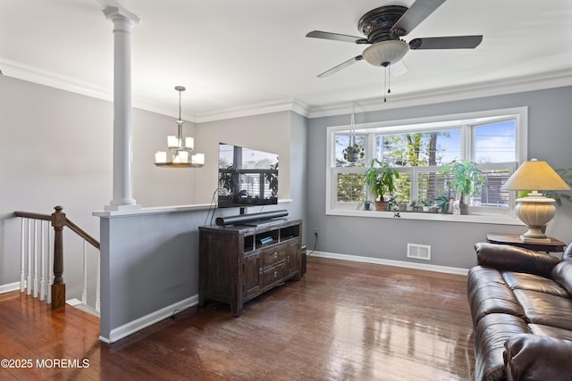 living area featuring crown molding, decorative columns, and wood finished floors