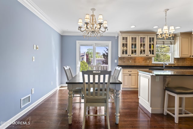 dining space with plenty of natural light, ornamental molding, visible vents, and a notable chandelier