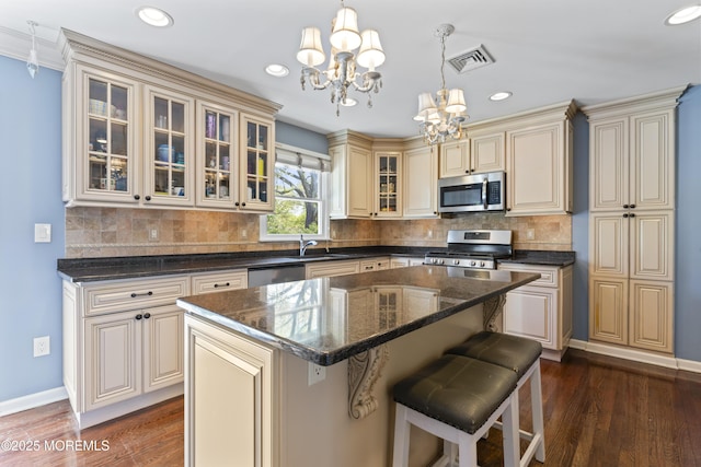 kitchen with visible vents, baseboards, cream cabinetry, appliances with stainless steel finishes, and a notable chandelier