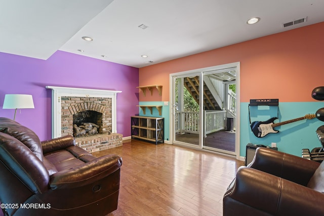 living room featuring a fireplace, recessed lighting, baseboards, wood finished floors, and visible vents
