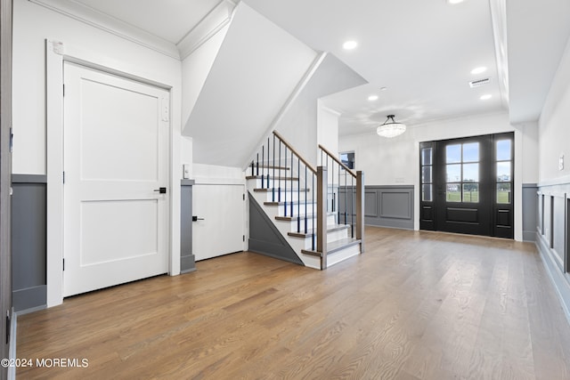 entryway featuring recessed lighting, stairway, wood finished floors, crown molding, and a notable chandelier