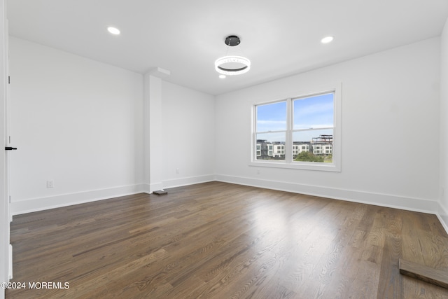 unfurnished room featuring dark wood finished floors, baseboards, and recessed lighting