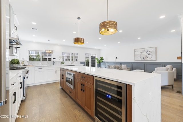 bar featuring built in microwave, light wood-type flooring, a wainscoted wall, decorative light fixtures, and wine cooler