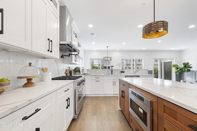 kitchen with a healthy amount of sunlight, stainless steel appliances, and white cabinetry