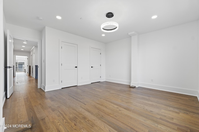 unfurnished bedroom featuring wood finished floors, baseboards, and recessed lighting