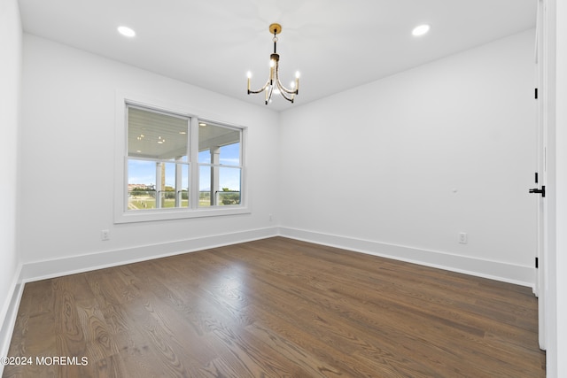 spare room with dark wood finished floors, baseboards, a chandelier, and recessed lighting