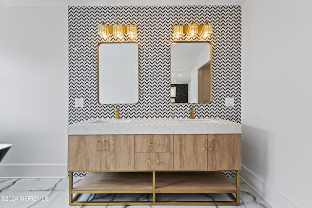 full bath with marble finish floor, baseboards, and a sink