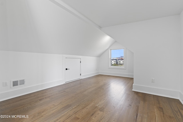 additional living space featuring lofted ceiling, wood finished floors, visible vents, and baseboards