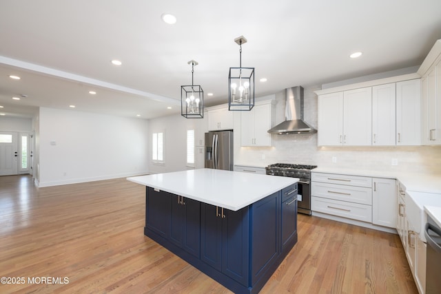 128 Church St, Keyport, NJ 07735 - kitchen featuring wall chimney exhaust hood, appliances with stainless steel finishes, tasteful backsplash, a center island, and light countertops