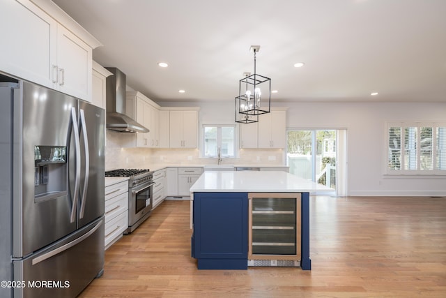 128 Church St, Keyport, NJ 07735 - kitchen with appliances with stainless steel finishes, beverage cooler, wall chimney exhaust hood, light countertops, and a chandelier