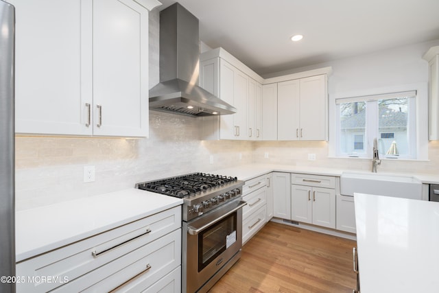 128 Church St, Keyport, NJ 07735 - kitchen with high end stainless steel range oven, wall chimney range hood, light countertops, decorative backsplash, and recessed lighting