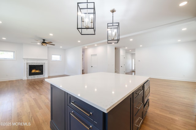128 Church St, Keyport, NJ 07735 - kitchen featuring open floor plan, ceiling fan, light countertops, light wood-style flooring, and stainless steel microwave