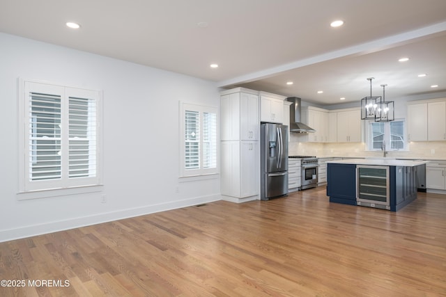 128 Church St, Keyport, NJ 07735 - kitchen featuring stainless steel appliances, wall chimney exhaust hood, beverage cooler, light countertops, and backsplash