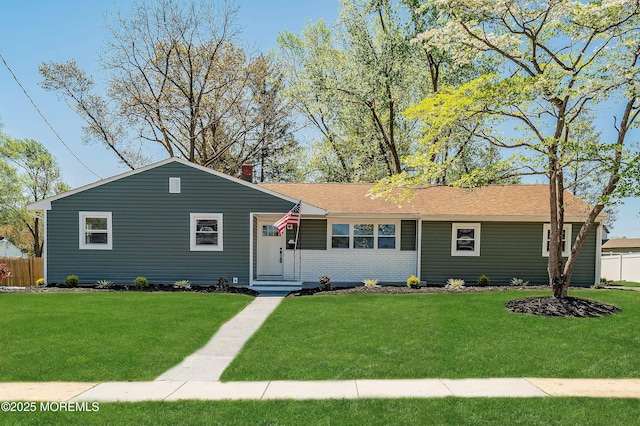 ranch-style house with brick siding, fence, and a front lawn
