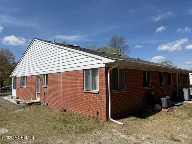 view of home's exterior featuring brick siding and central AC unit