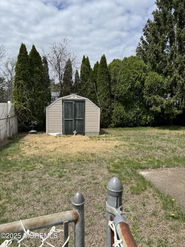 view of yard with an outdoor structure, fence, and a shed