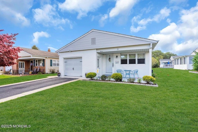 view of front of property featuring a porch, a front lawn, an attached garage, and driveway