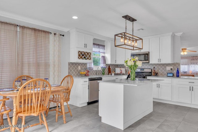 kitchen featuring a sink, light countertops, ornamental molding, and stainless steel appliances