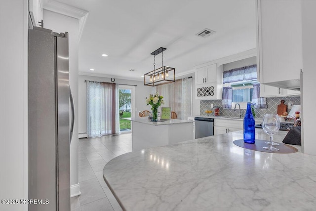 kitchen with visible vents, appliances with stainless steel finishes, tasteful backsplash, light stone counters, and white cabinetry