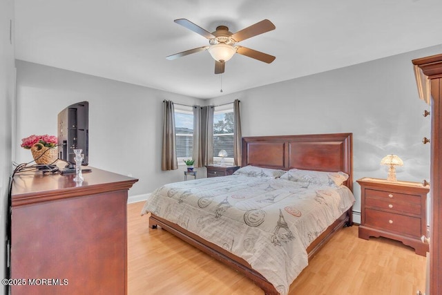 bedroom featuring baseboards, a ceiling fan, and light wood finished floors
