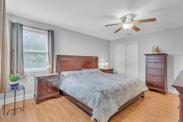 bedroom featuring light wood-style floors, baseboards, ceiling fan, and a closet
