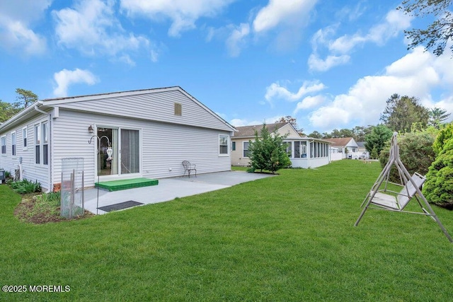 back of property featuring a patio, a yard, and a sunroom