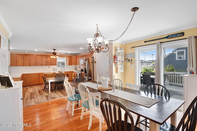 dining area with crown molding, recessed lighting, ceiling fan with notable chandelier, and light wood-style floors