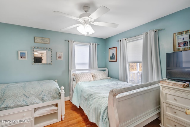 bedroom with a ceiling fan, multiple windows, and light wood-style floors