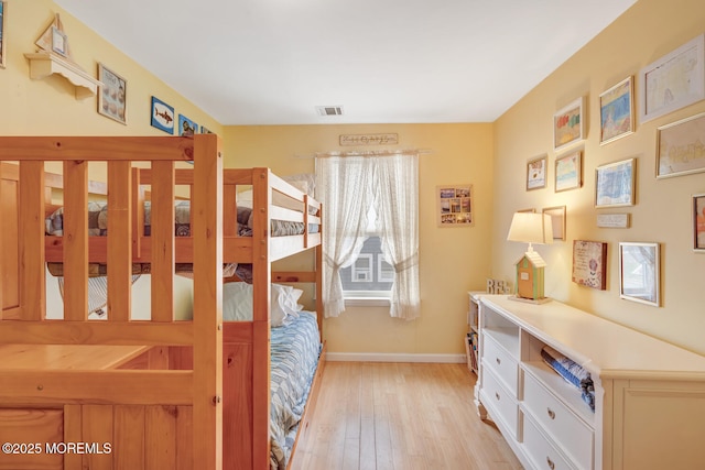 bedroom featuring light wood-style floors, baseboards, and visible vents