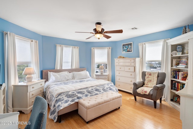 bedroom featuring ceiling fan, visible vents, and light wood-style flooring