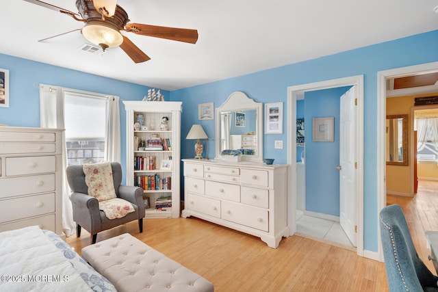 bedroom featuring ceiling fan, visible vents, multiple windows, and light wood-style floors