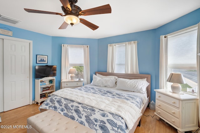 bedroom featuring visible vents, light wood-style floors, and ceiling fan