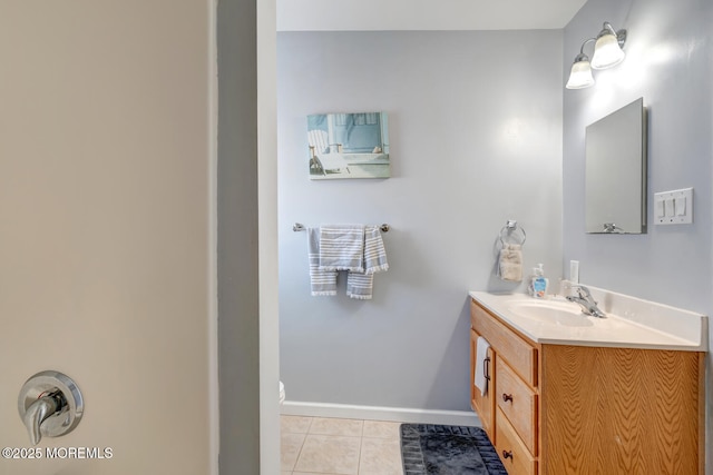 bathroom with vanity, baseboards, and tile patterned floors